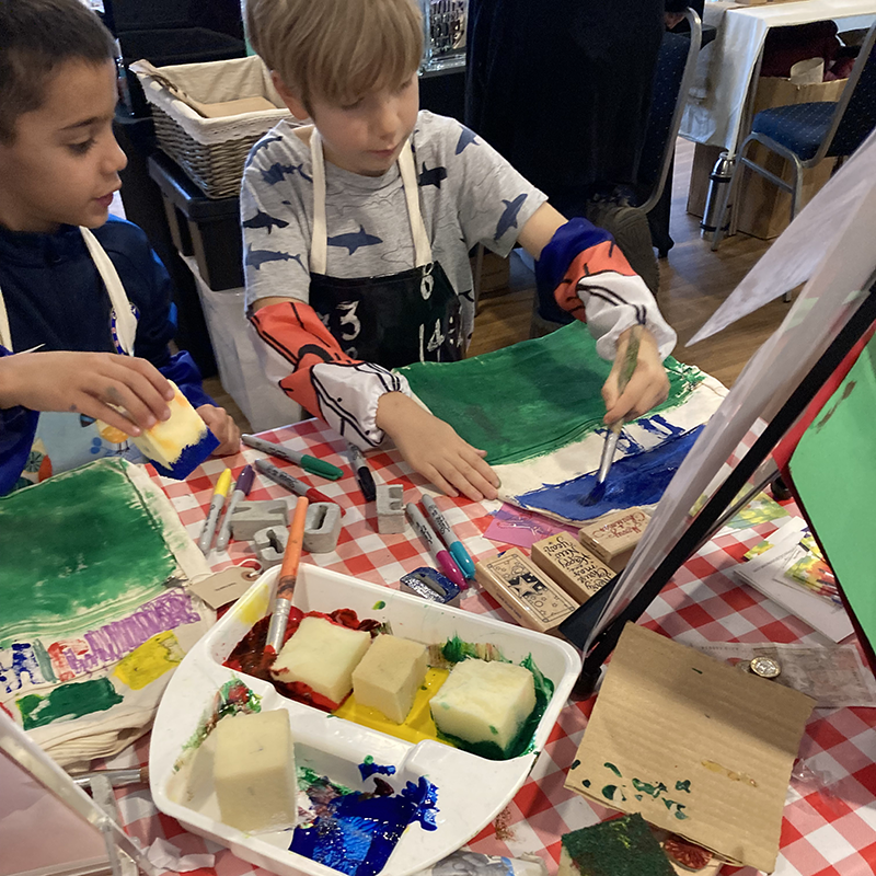 image of scouts painting a design a bag in sussex